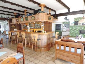 un restaurante con un bar con mesas y sillas de madera en Gasthaus Weber, en Wiesemscheid
