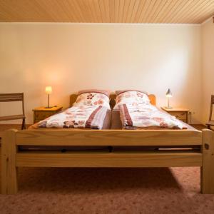een slaapkamer met een houten bed met 2 kussens bij Haus Gartenstrasse in Merzig