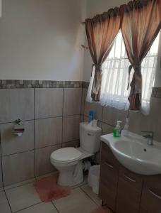 a bathroom with a toilet and a sink at Sleep@161 Benade Drive in Bloemfontein