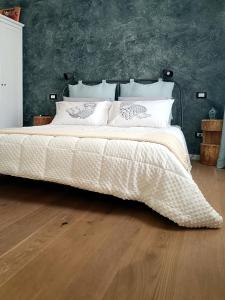 een bed met een wit dekbed in een slaapkamer bij Stanza Allegra Soave in Soave