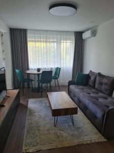 a living room with a couch and a table at Talsa 1-bedroom apartment in city center Šiauliai in Šiauliai
