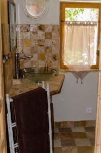 baño con lavabo y ventana en L'Oustaou des Monges, en Mollans-sur-Ouvèze