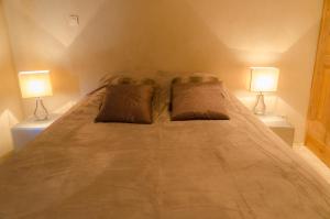 a bedroom with a large bed with two lamps at L'Oustaou des Monges in Mollans-sur-Ouvèze