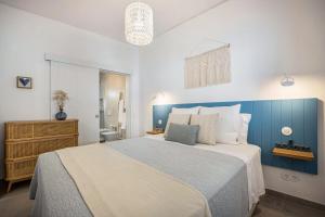 una camera con un grande letto con testiera blu di Casa Mateus a Vila do Bispo