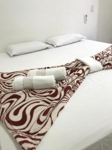 two beds with white sheets and a brown and white blanket at Pousada Trilha do Sol in Pirenópolis +106 photos
