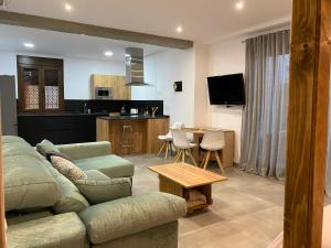 ein Wohnzimmer mit Couch und Tisch und eine Küche in der Unterkunft Apartamentos La Cámara II Córdoba Corredera in Córdoba