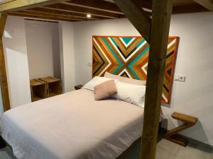 ein Schlafzimmer mit einem Bett und einem Gemälde an der Wand in der Unterkunft Apartamentos La Cámara II Córdoba Corredera in Córdoba