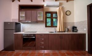 a kitchen with wooden cabinets and a sink and a refrigerator at OREADES-HOMES in Áno Khóra