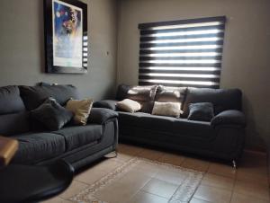 a living room with two couches and a window at Departamento Equipado á 3 minutos del Consulado americano 2 RECAMARAS in Manuel F. Martínez