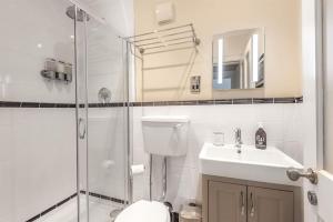 a bathroom with a shower and a toilet and a sink at Rowntree One - Stunning Apartment- Grade II listed in York