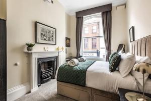 een slaapkamer met een bed, een open haard en een raam bij Rowntree One - Stunning Apartment- Grade II listed in York
