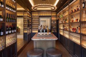 a bar in a wine cellar with bottles of wine at Horsted Place Hotel in Uckfield