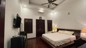 a bedroom with a bed and a flat screen tv at Yen Homestay in Hanoi