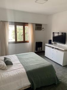 a bedroom with a bed and a flat screen tv at Departamento Temporario calle Pico 1 in Santa Rosa