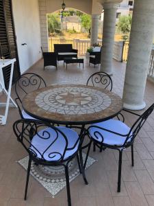a patio with a table and chairs on a patio at B&B Rosa dei Venti in Roseto Capo Spulico