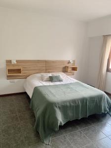 a bedroom with a large bed with a wooden headboard at Departamento Temporario calle Pico 1 in Santa Rosa