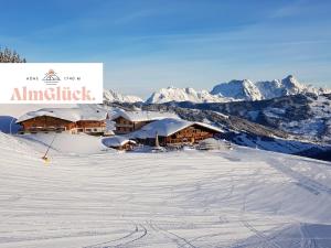 eine Skihütte im Schnee mit Bergen im Hintergrund in der Unterkunft AlmGlück Chalet auf 1740m in Saalbach-Hinterglemm