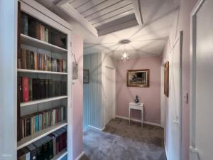 a hallway with bookshelves and a table in a room at Charming cottage within farmhouse in Monmouth