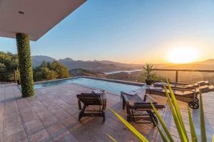 a villa with a swimming pool with a view of the mountains at Villa Fahrenheit in El Gastor