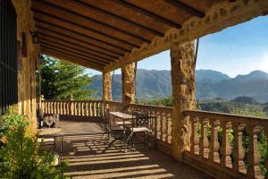 a wooden porch with a table and chairs on it at El Valle Dorado in El Gastor