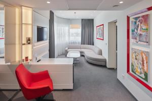 維爾紐斯的住宿－維爾紐斯假日酒店，配有书桌和红色椅子的房间