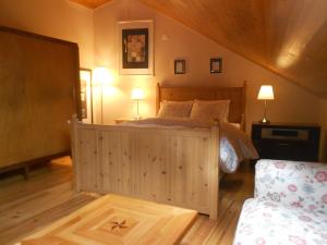 a bedroom with a wooden bed with two lamps and a couch at Sintra Small Hostel in Sintra