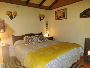 a bedroom with a bed with two pillows on it at Complejo Cabañas Pétalos in Villarrica