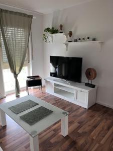 a living room with a tv and a white table at Good living in Schwetzingen