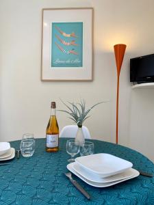 a table with a bottle of wine and plates on it at Résidence du Parad'Ice in Dinard