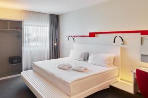 a bedroom with a bed with two towels on it at Holiday Inn Vilnius, an IHG Hotel in Vilnius