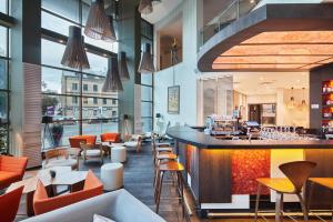 a restaurant with a bar and tables and chairs at Holiday Inn Vilnius, an IHG Hotel in Vilnius