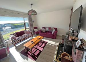 a living room with two couches and a table at The Nook Oranmore Holiday Home in Oranmore
