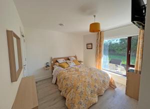 1 dormitorio con cama y ventana grande en The Nook Oranmore Holiday Home en Oranmore