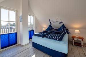 a bedroom with a bed with blue and white pillows at Meeresrauschen - a57674 in Kramerhof