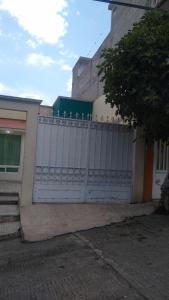 une clôture blanche devant un bâtiment dans l'établissement Linda casa tipo loft, con estacionamiento privado., à Tulancingo