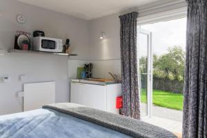 a bedroom with a bed and a large window at Hawk's Nest in Wadebridge