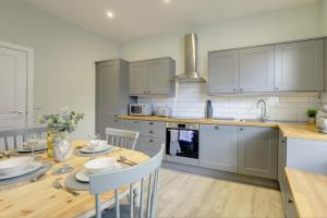 a kitchen with a wooden table with a dining room at The Nook - A modern 2 bedroom loft with parking in Ripon