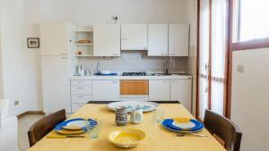 アルゲーロにある2 Balconies Apartment - Wonderful Algheroのキッチン(木製テーブル、青い皿付)