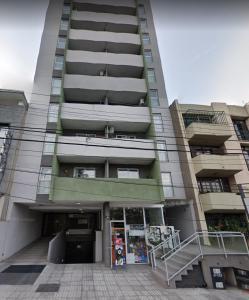 un edificio alto con una tienda delante en Departamento - Edificio Costanera en San Salvador de Jujuy