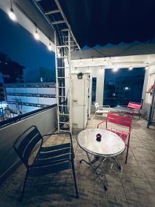 a room with two chairs and a table and a refrigerator at Alleyway Hostel in Ho Chi Minh City