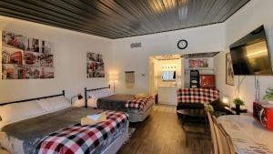 een slaapkamer met 2 bedden, een bureau en een bank bij Sussex Motel in Wantage