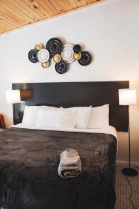 um quarto com uma cama com pratos na parede em Sussex Motel em Wantage