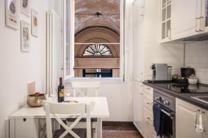 une cuisine blanche avec une table et une fenêtre dans l'établissement Clavature Suite, à Bologne