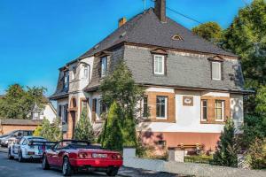 a red car parked in front of a house at Villa Mondial in Wadern