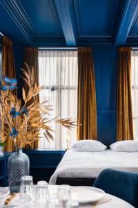 a blue bedroom with a bed and a window at De Olde Signorie in Leeuwarden