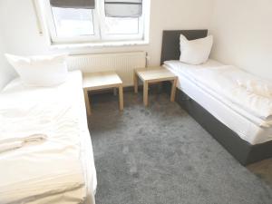 pokój z dwoma łóżkami i stołem w obiekcie SUNNYHOME Monteurwohnungen und Apartments in Bodenwöhr w mieście Bodenwöhr