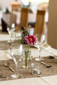 a table with wine glasses and a vase with flowers at Hotel Viktor in Viktorsberg