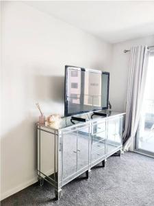 a glass dresser with a mirror on it in a room at Entire apartment with lake view in Tuggeranong