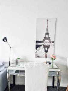 a desk with a chair and a picture of the eiffel tower at Entire apartment with lake view in Tuggeranong