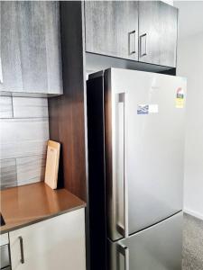 a kitchen with a stainless steel refrigerator and cabinets at Entire apartment with lake view in Tuggeranong